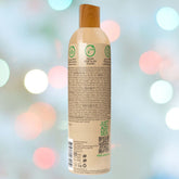 The bottle of Wet Naturally features a wooden cap with text and symbols indicating it is an environmentally friendly, vegan lubricant made with 95% organic aloe. The blurred background of colorful bokeh lights adds a festive atmosphere.